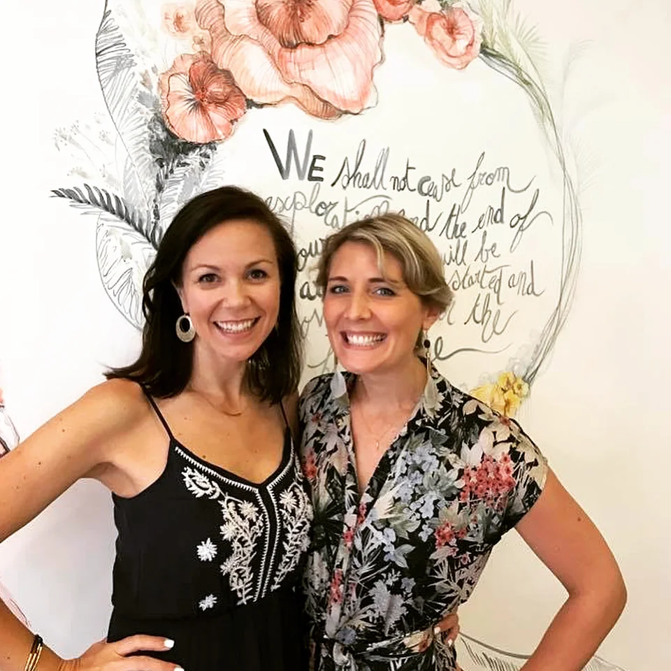 Willo Sana with an attendee in front of a hand-lettered floral mural